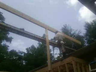 Carpenter setting a ridge beam over a new addition frame — Ice Dam Removal by Roofing Brothers in Anthony